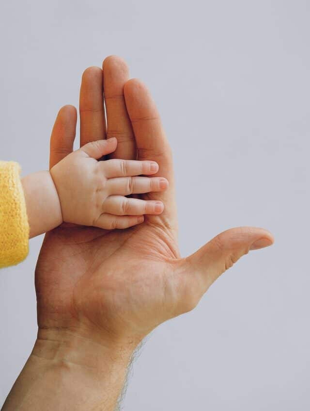 pexels-anna-shvets-3845458 baby hand in adult hand